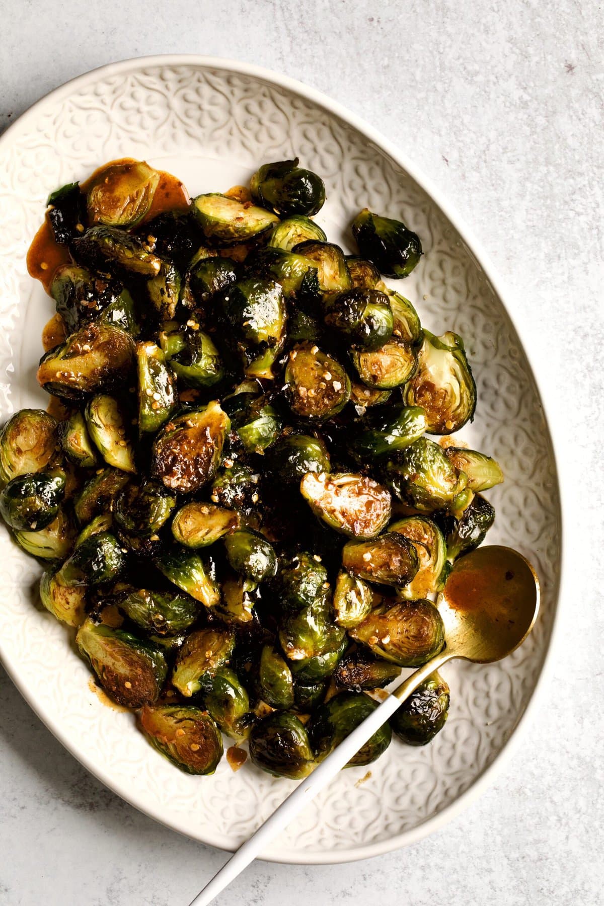 Crispy Brussels Sprouts Recipe on a cream colored serving platter.