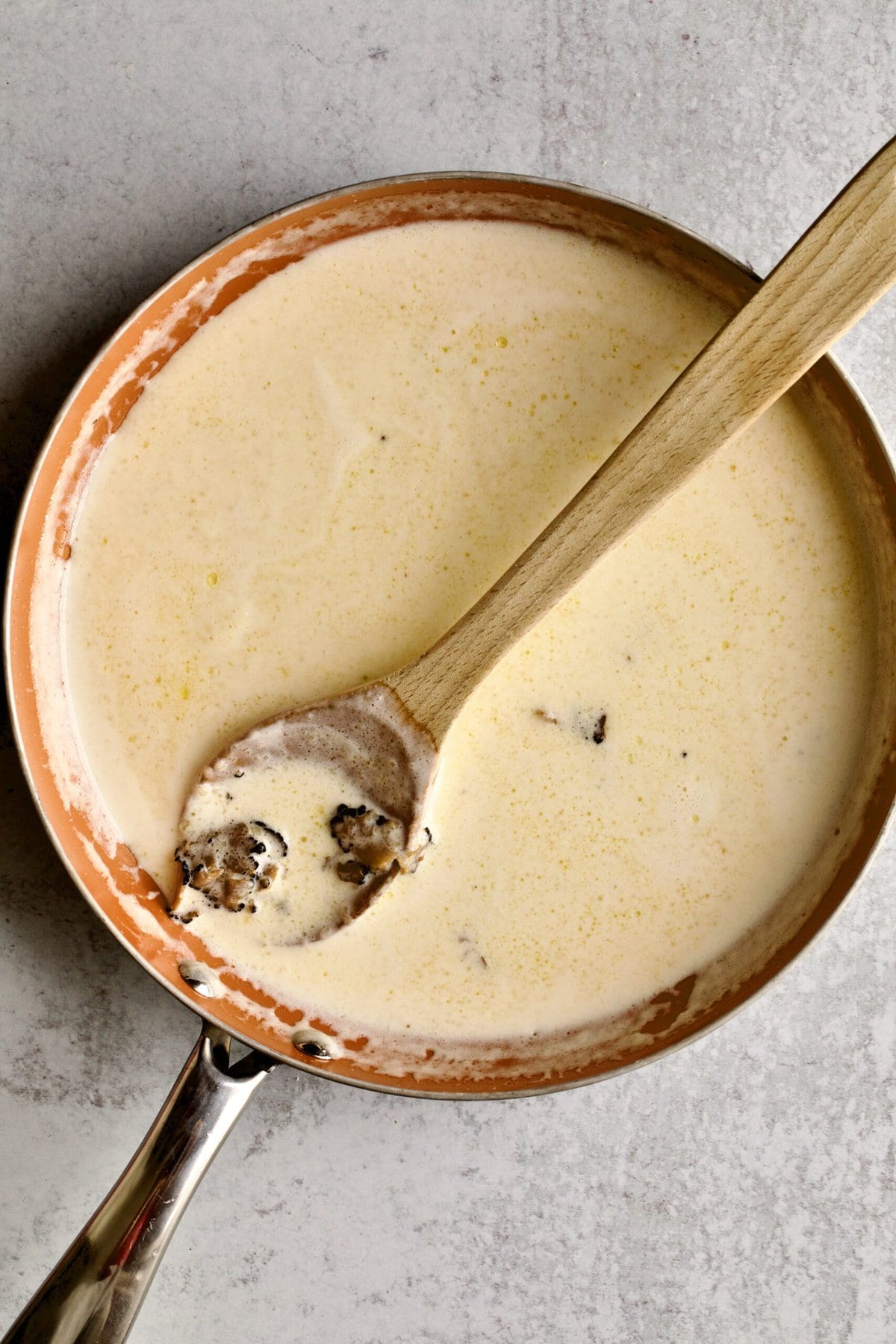 instructions for black truffle cream sauce: adding cream, parmigiano cheese and truffles.