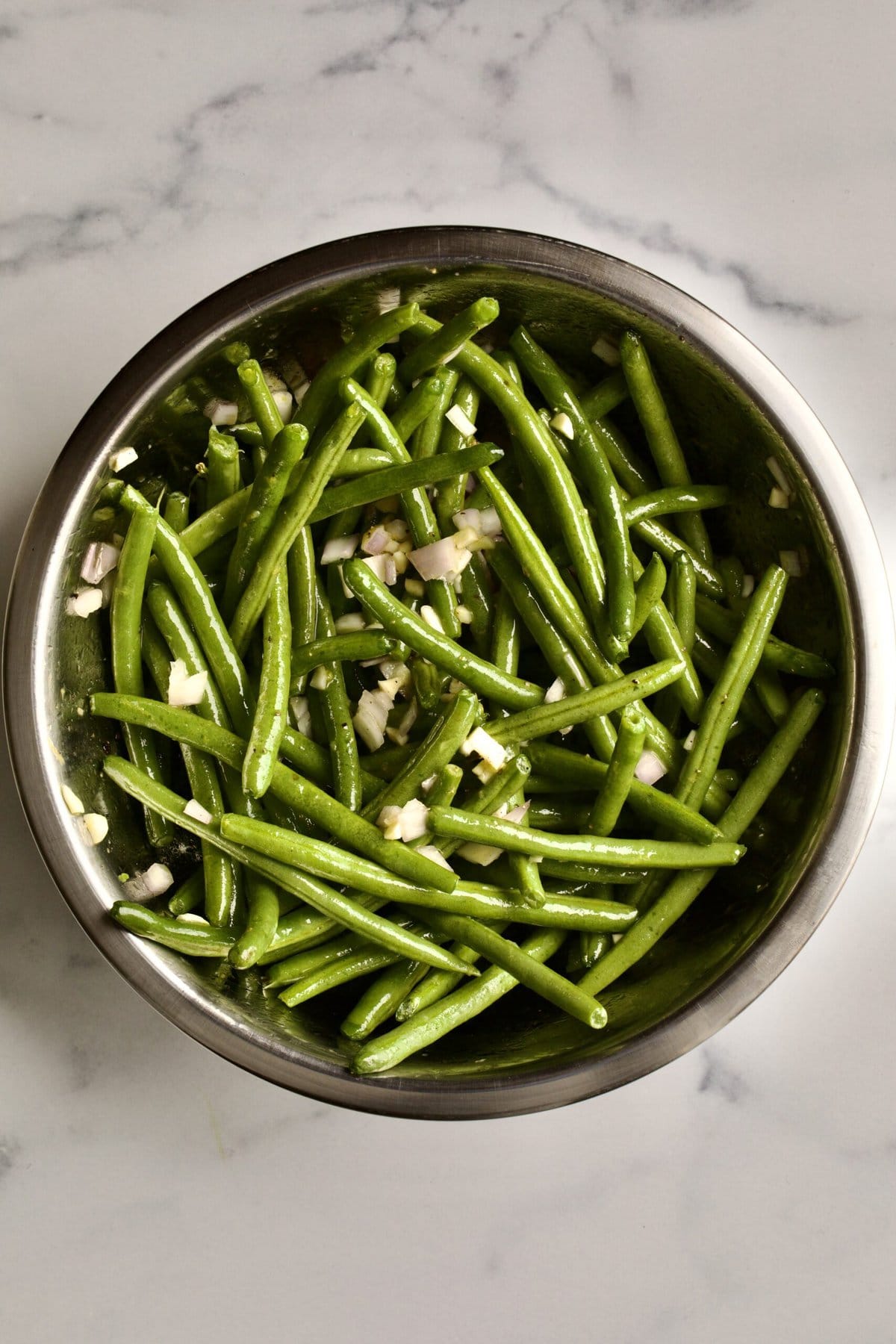 process: adding marinate to raw green beans.