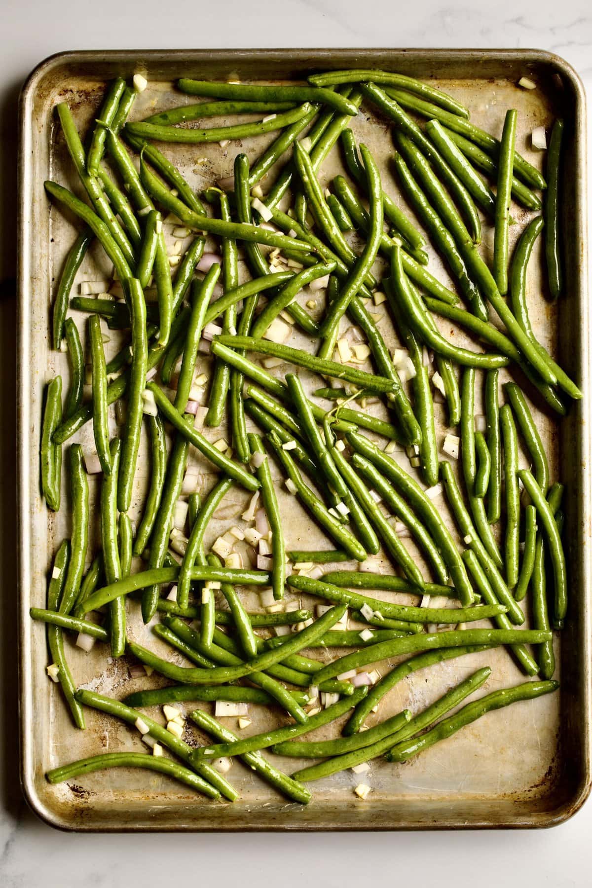 placing green beans on sheet pan to bake.