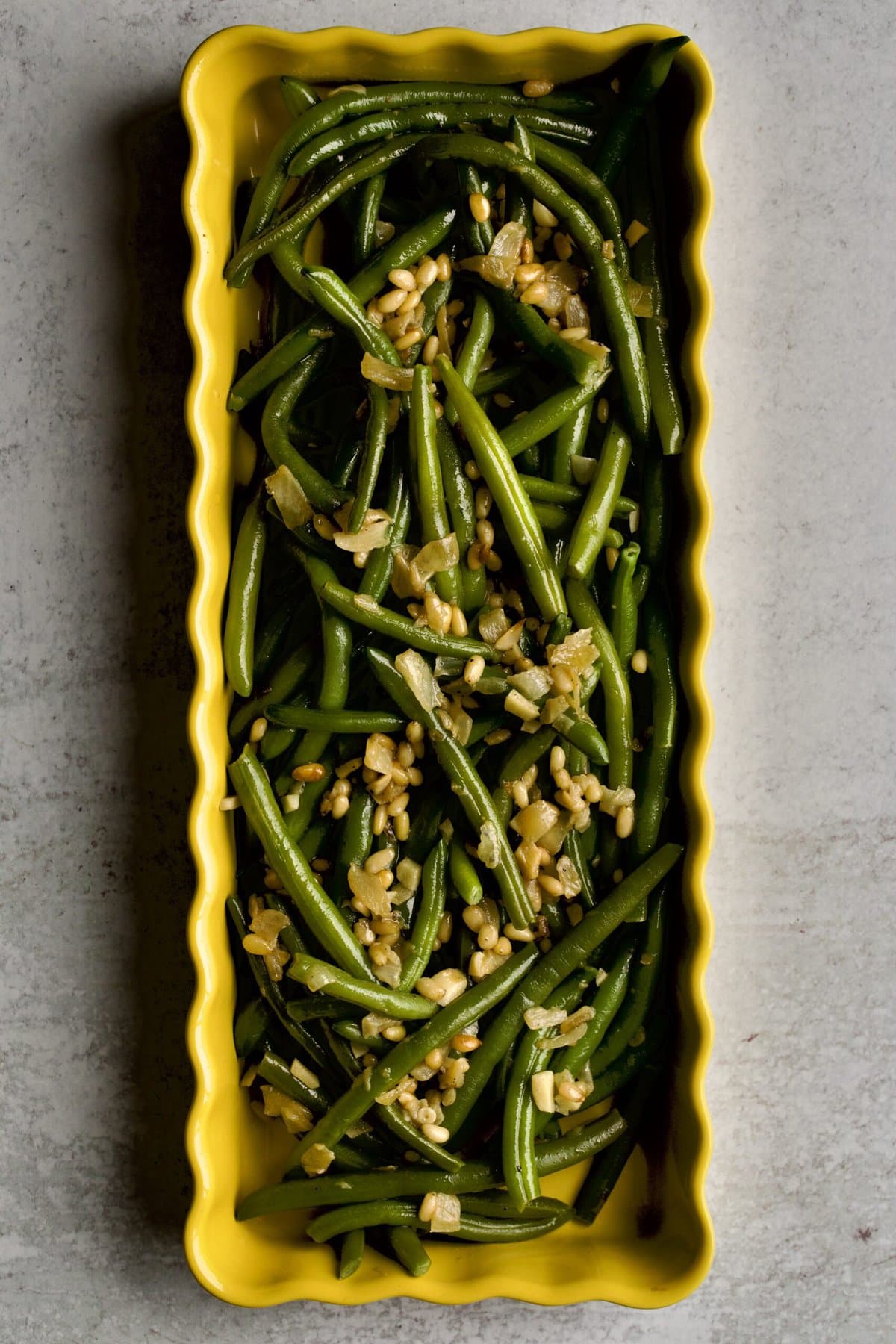 Sautéed Frozen Green Beans Recipe (Easy) on a yellow serving platter.