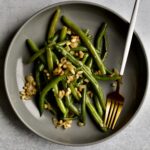 Sautéed Frozen Green Beans Recipe (Easy) on a grey plate with a fork.