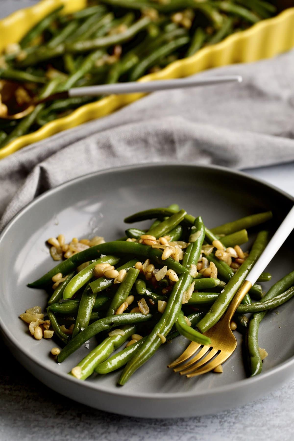 Sautéed Frozen Green Beans Recipe (Easy) on a grey plate with a fork