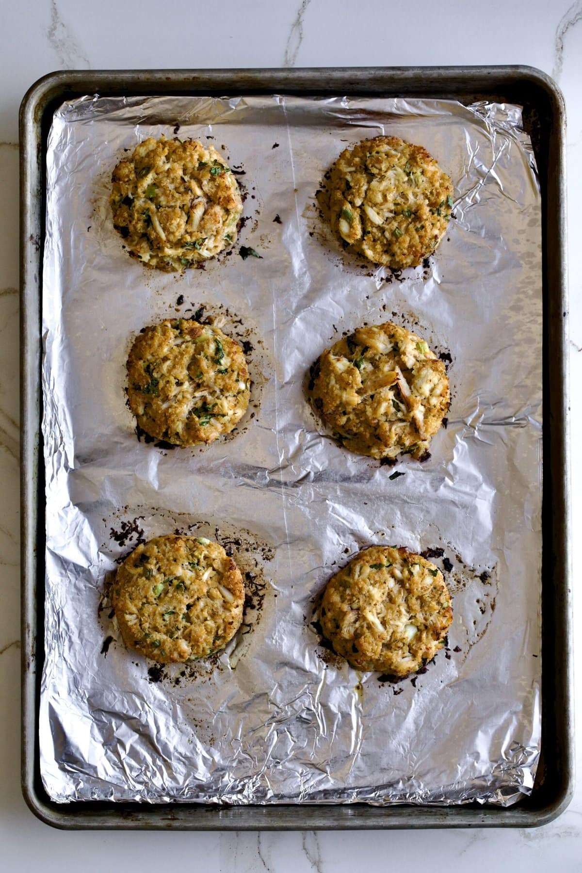 process. Baked crab cakes on baking sheet.