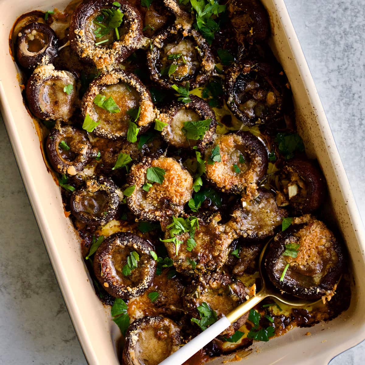 Spoon in a tray of roasted portobello caps with balsamic and thyme.