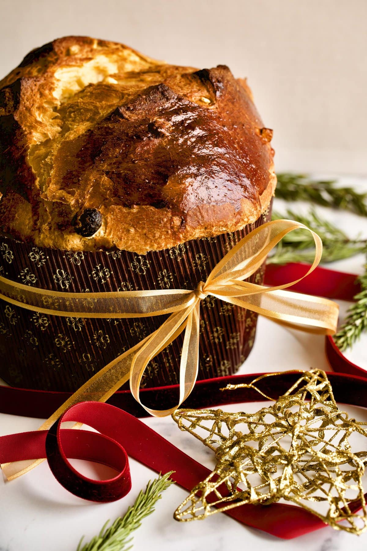 traditional panettone top down of final cooked cake. Golden Christmas star in background.