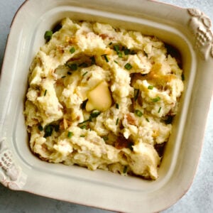 Square bowl of red skin mashed potatoes with roasted garlic.