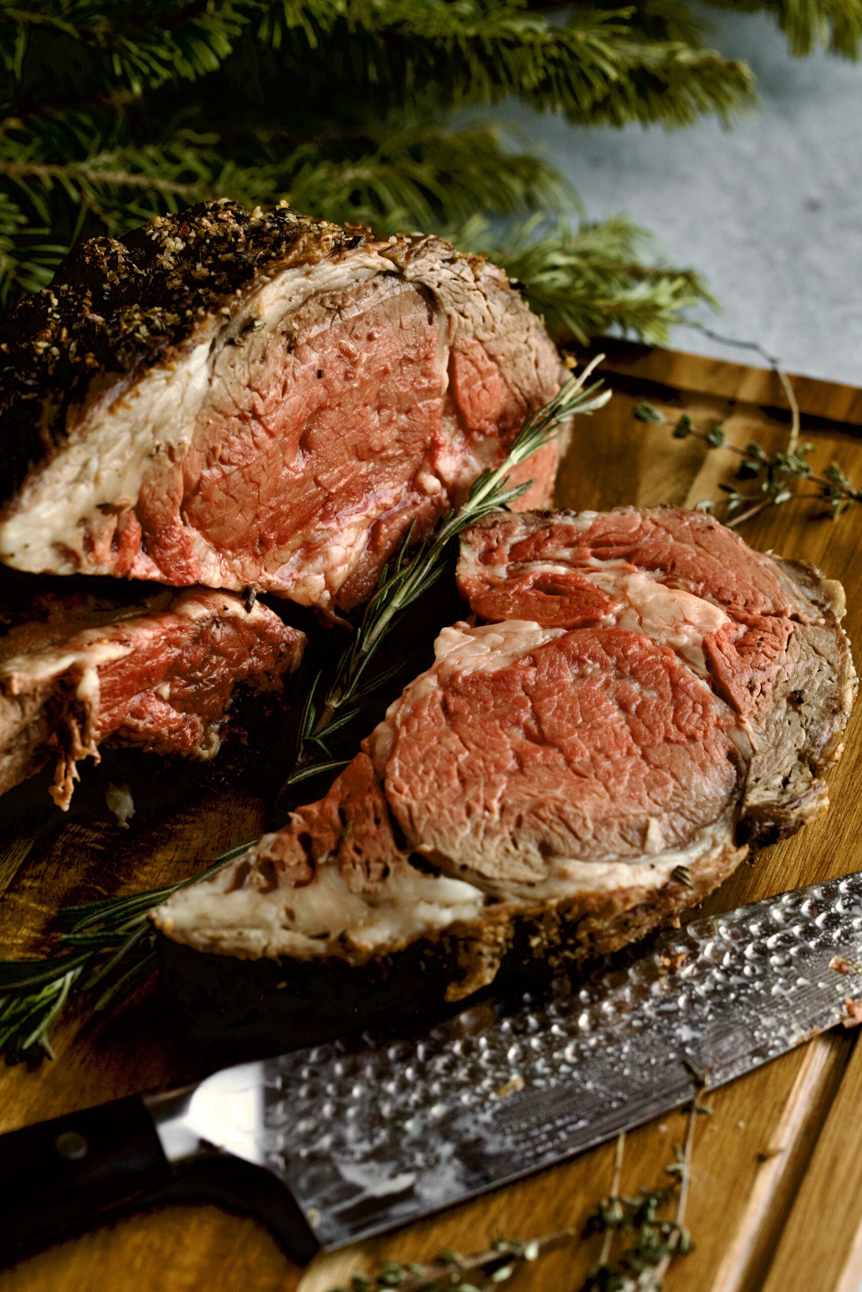 thick slice cut from prim rib roast on a cutting board.