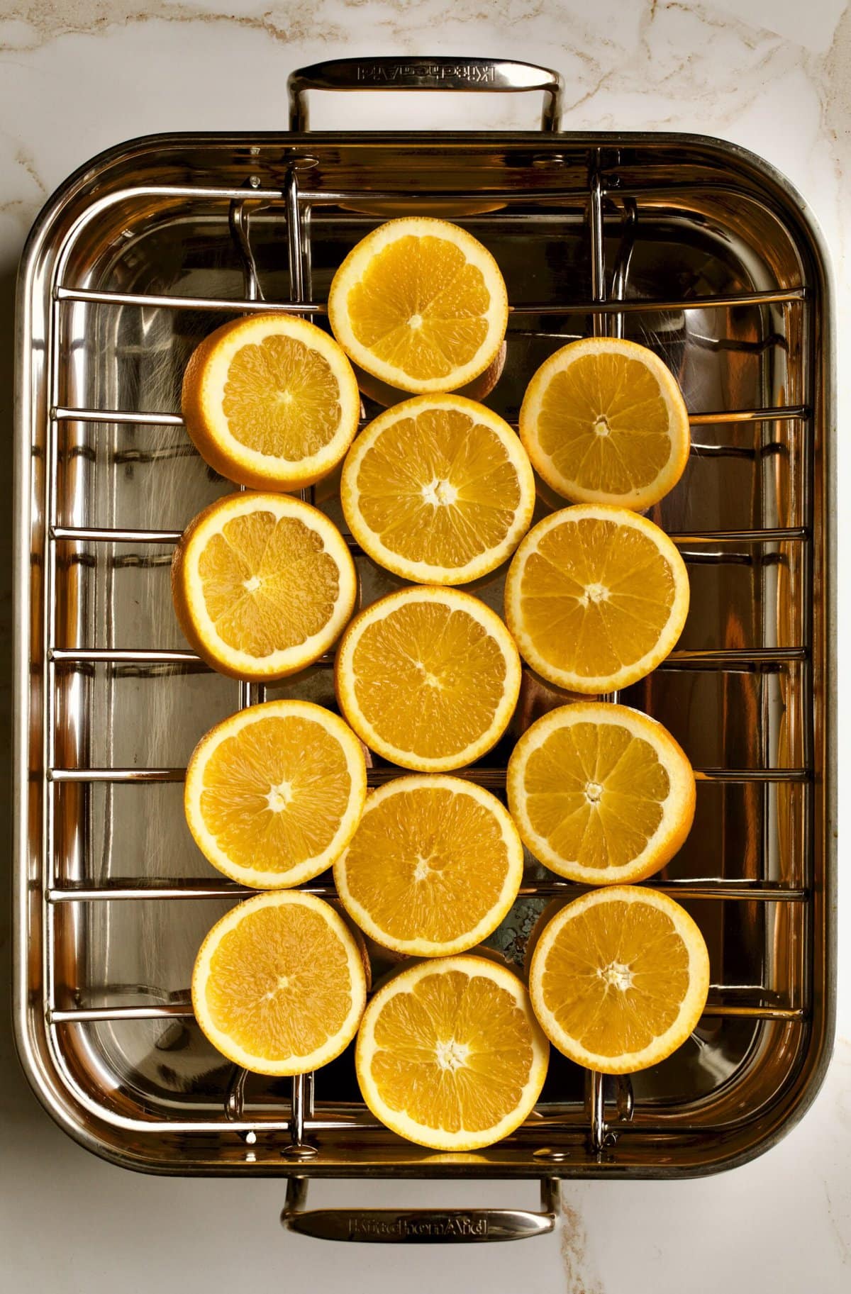 process of making fresh ham roast. Orange slices on bottom of roasting pan.