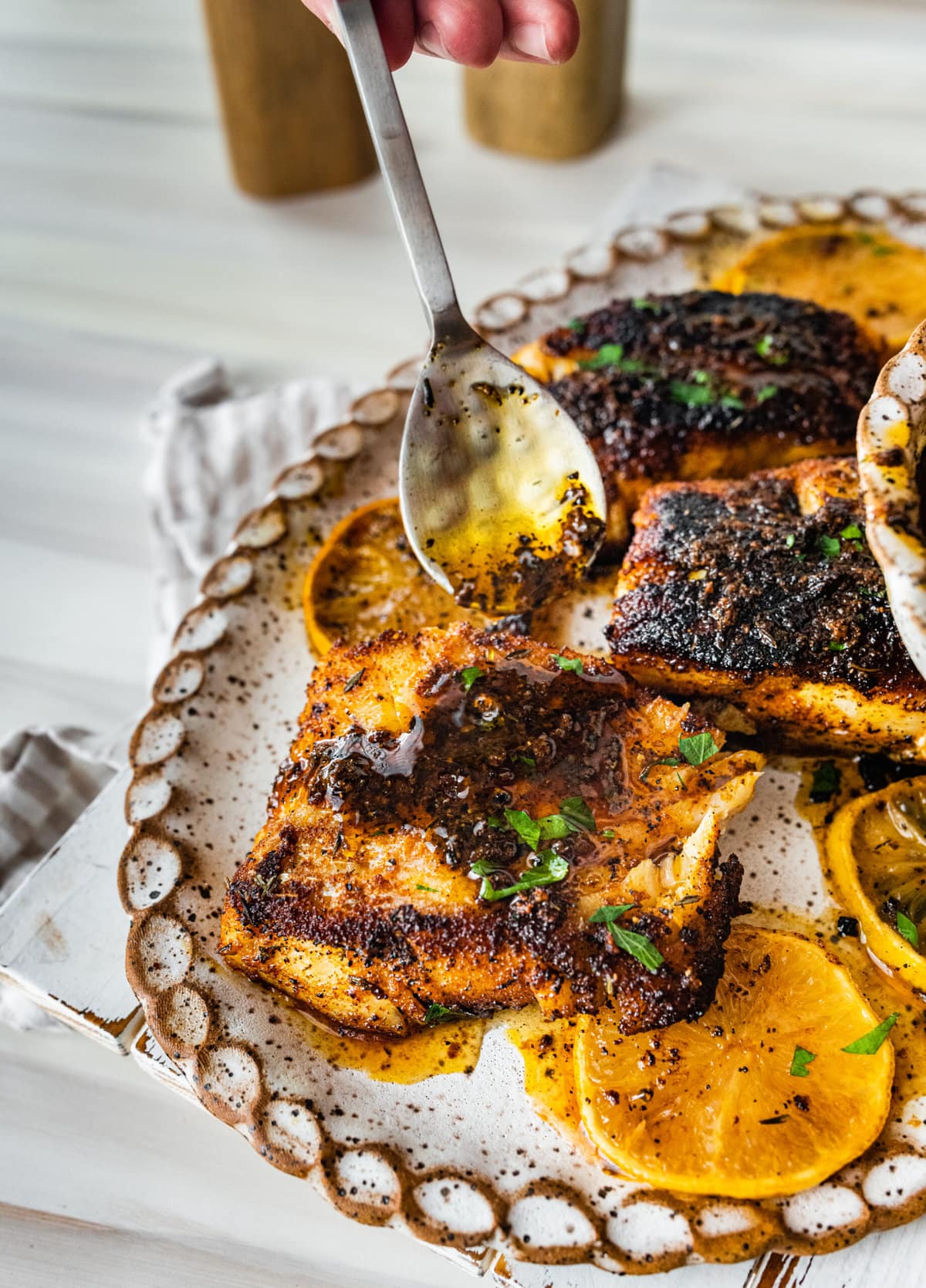 Easy Blackened Cod Recipe on a white platter with pan juices.