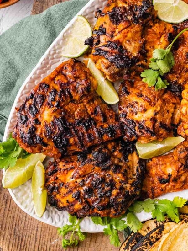 Pollo Asado Recipe (Chipotle Copycat) made into a rice bowl with sides on a platter