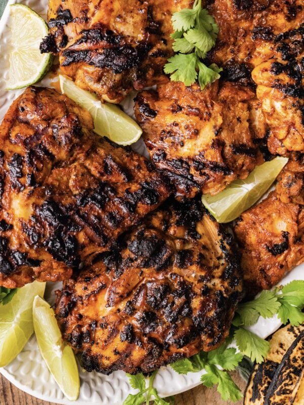 Pollo Asado Recipe (Chipotle Copycat) made into a rice bowl with sides on a platter.