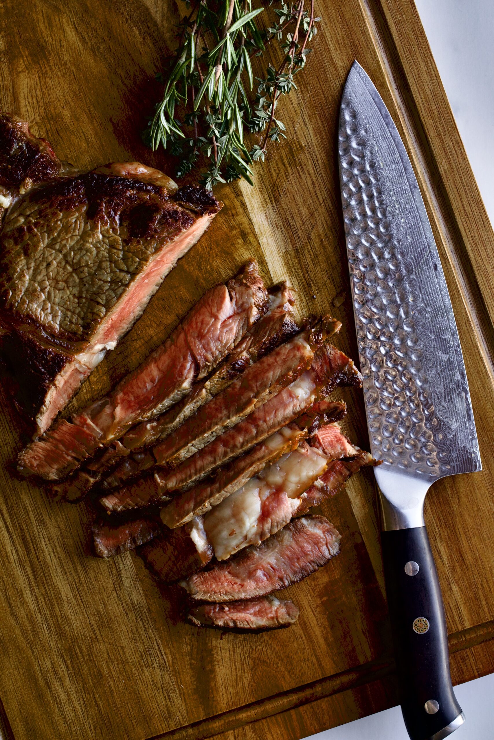 How to Cook Steak in a Pan (Perfect Recipe)- cutting the steak on a cutting board.
