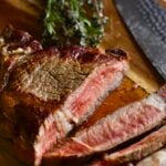 How to Cook Steak in a Pan (Perfect Recipe)- cutting the steak on a cutting board.