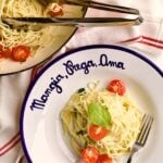 plate of angel hair pasta with herbs and garlic. Bof dish of pasta in the background.
