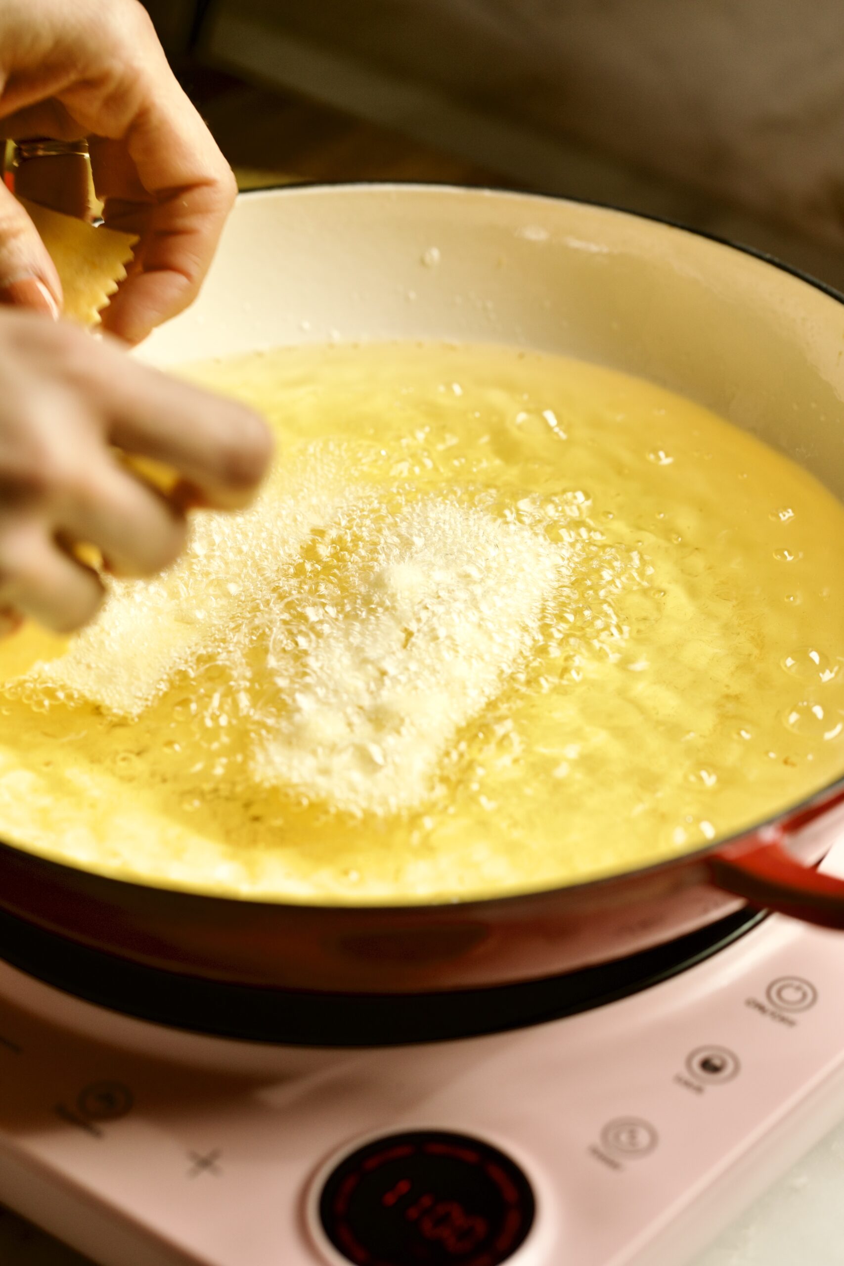 process of making chiacchiere: frying the dough frying in the hot oil.