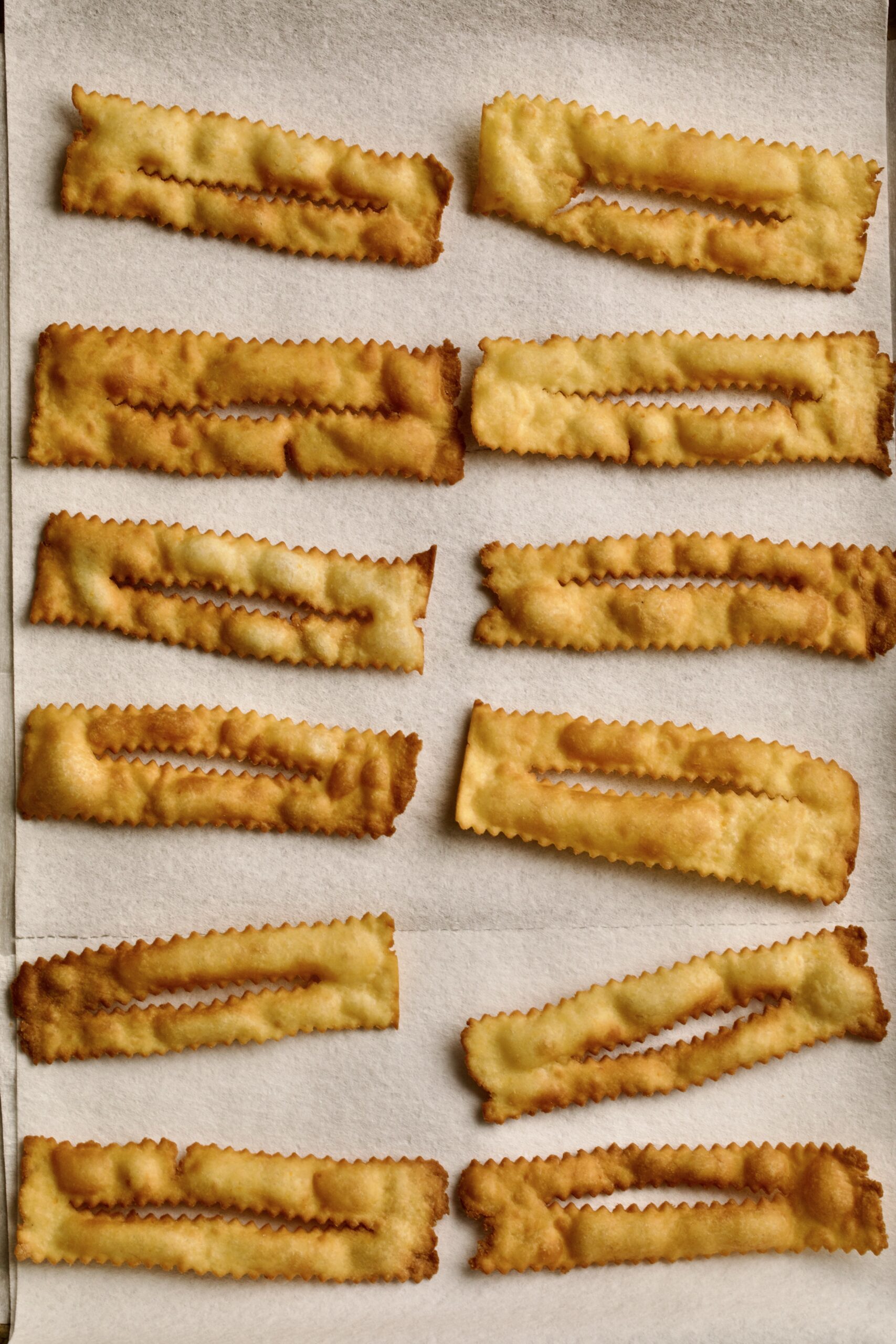 process of making chiacchiere: frying the dough frying in the hot oil setting fried dough to absorb on paper towels.