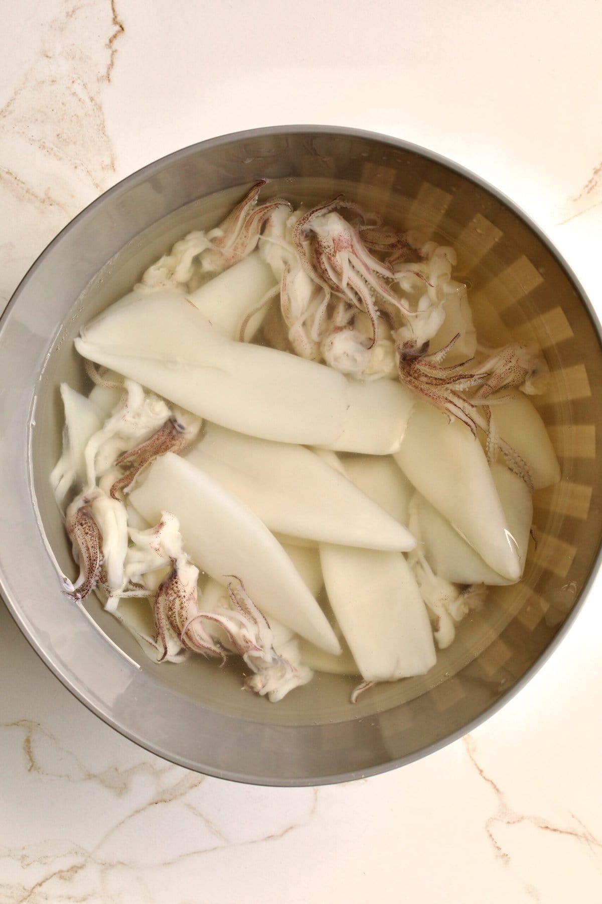 process of making Italian Stuffed Calamari Recipe in Tomato Sauce: washing calamari in water and drying them.