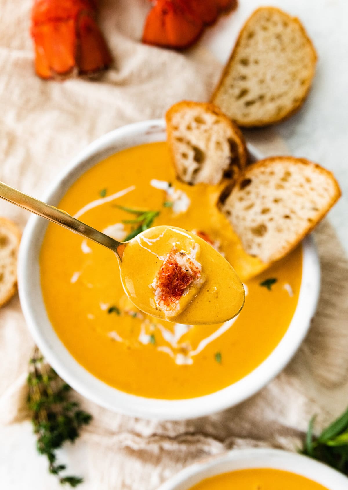 classic lobster bisque in a bowl with toasted bread slices in the bowl.