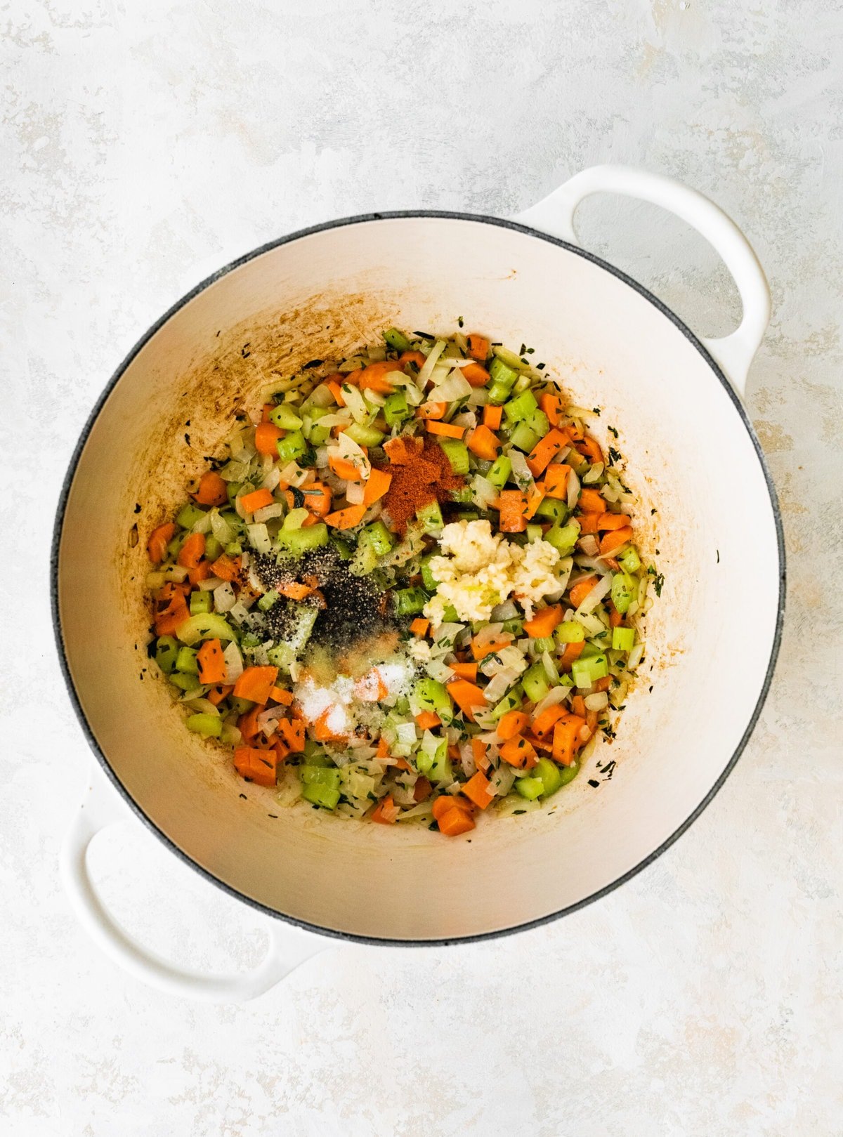 process of making classic lobster bisque: sautéing vegetables in pan.