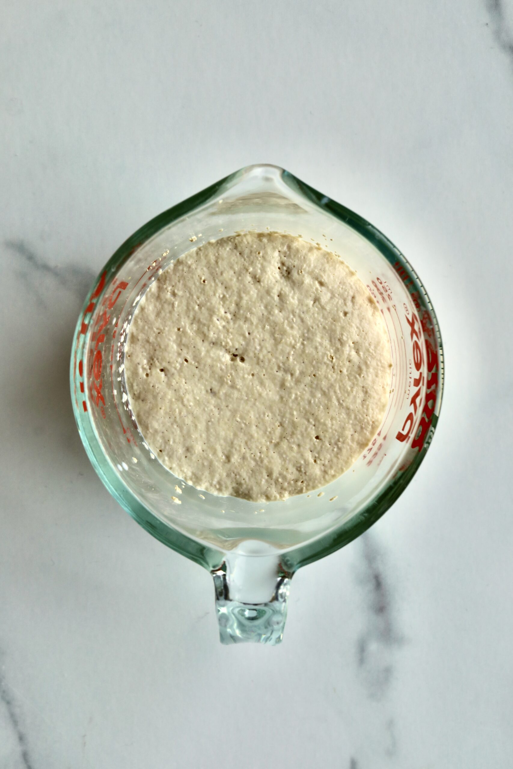 Process of making Bomboloni (how to make bomboloni recipe)- yeast in milk after bloom. Froth on top.