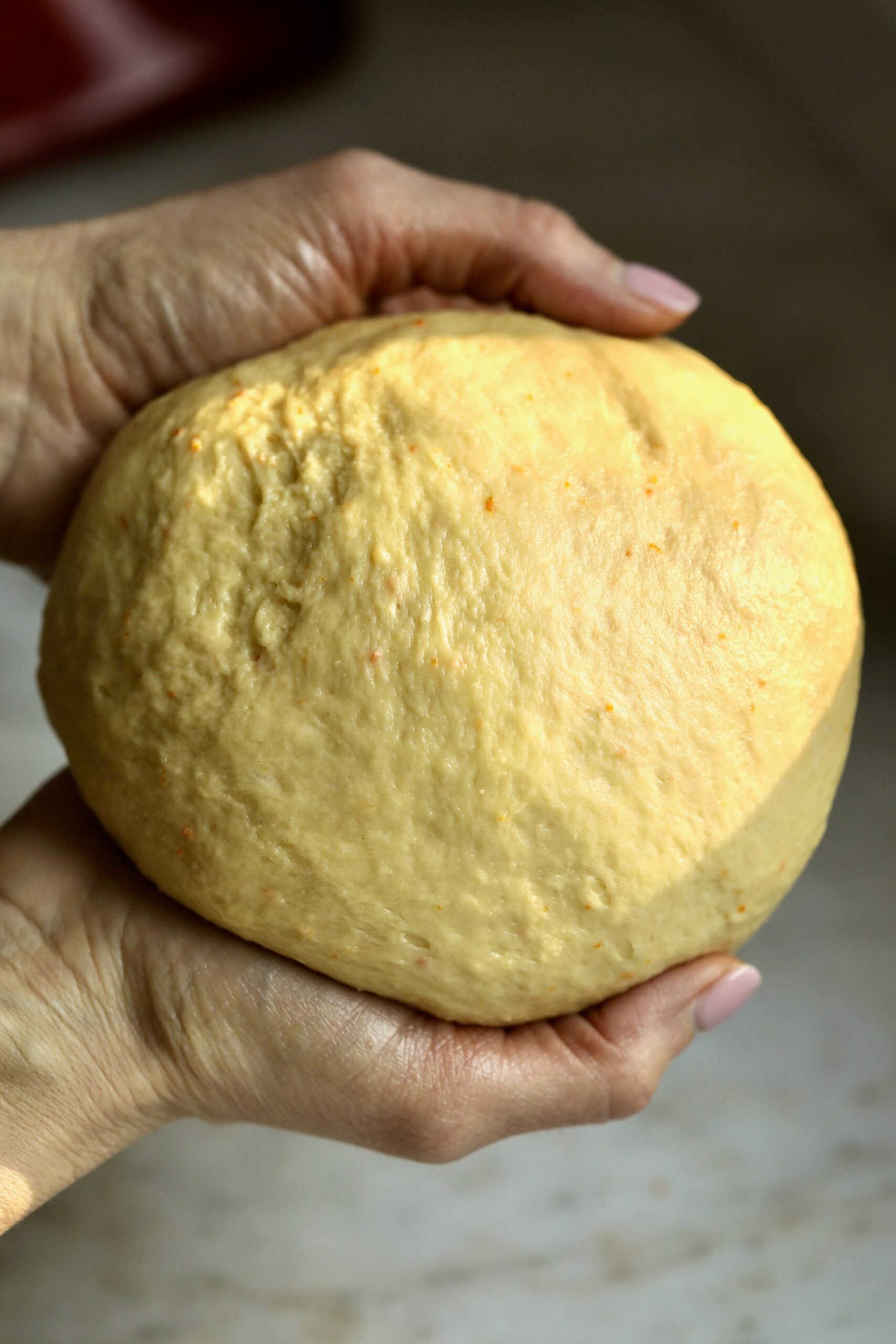 Process of making Bomboloni (how to make bomboloni recipe)- round dough ball ready to place into a greased bowl for first rise.