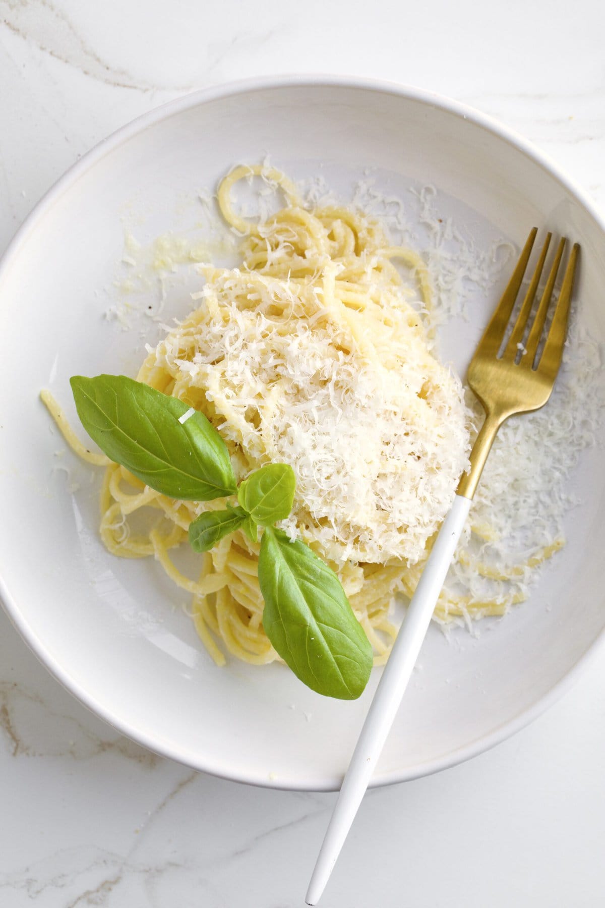 Lemon Butter Pasta Sauce (Pasta al Limone) in a serving bowl with basil on the side and fork in the plate.