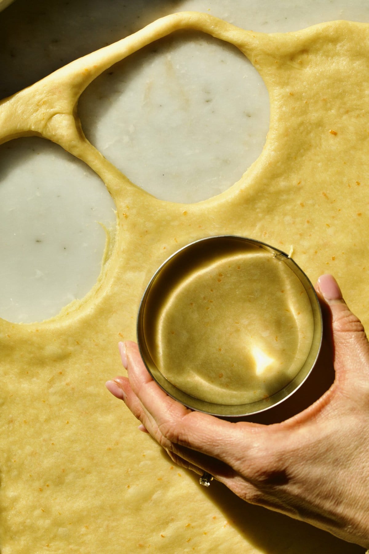 Process of making Bomboloni (how to make bomboloni recipe)- cutting out the dough into circles with round cookie cutter.