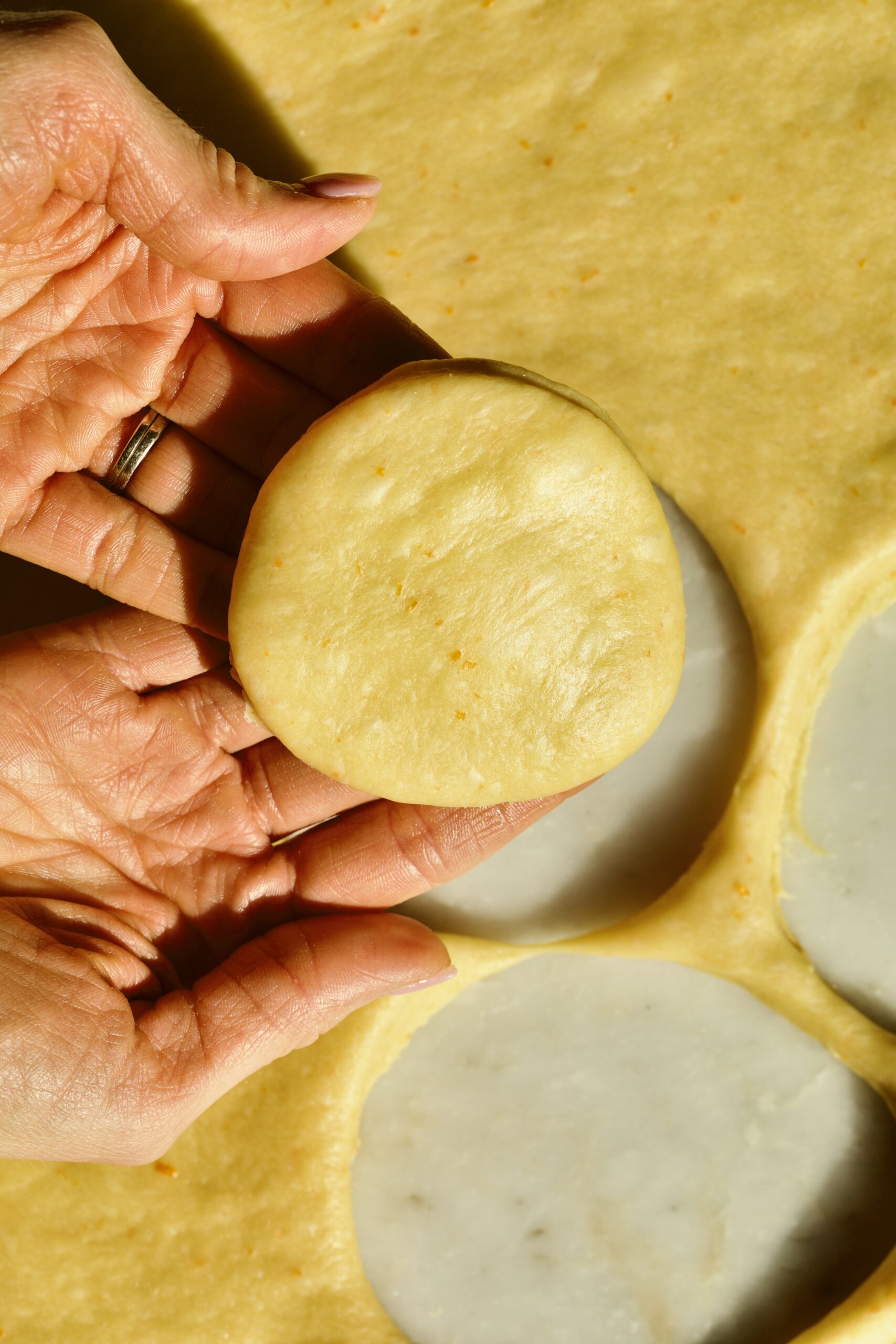 Process of making Bomboloni (how to make bomboloni recipe)- cutting out the dough into circles with round cookie cutter.