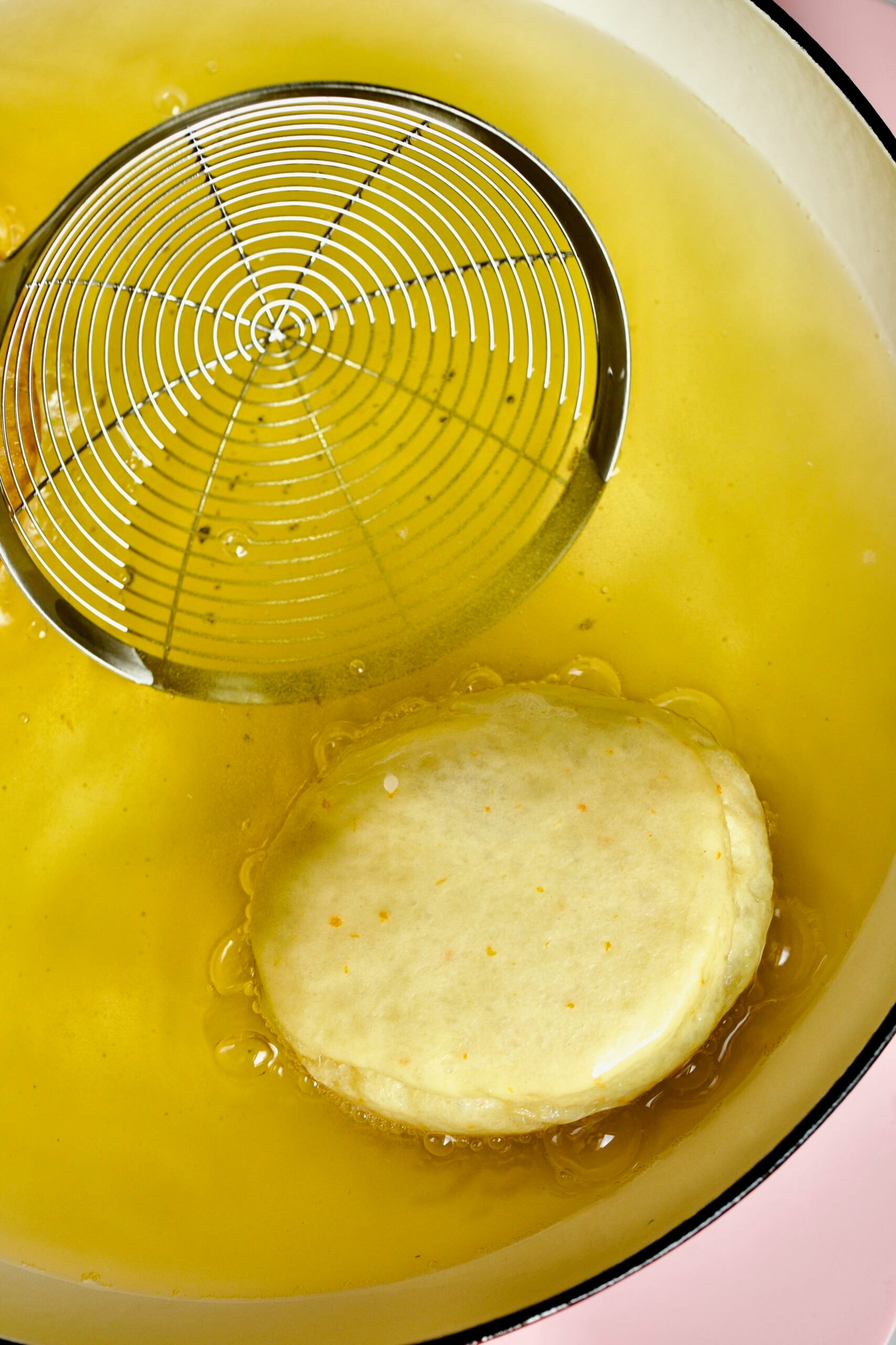 Process of making Bomboloni (how to make bomboloni recipe)- frying the donuts in oil- frying for 2 minutes on each side in oil.