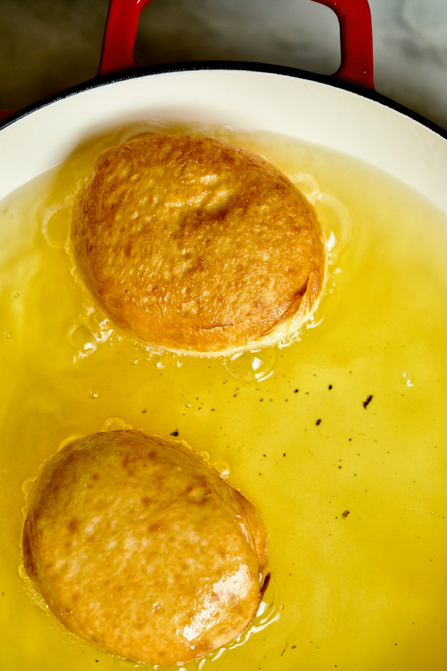 Process of making Bomboloni (how to make bomboloni recipe)- frying the donuts in oil-