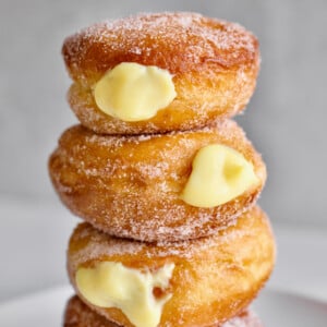 Bomboloni stacked on a plate.