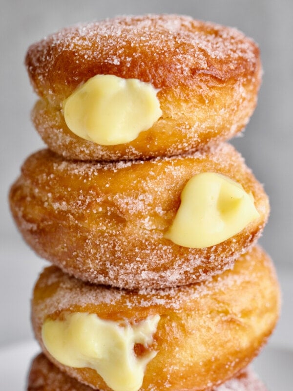 Bomboloni stacked on a plate.