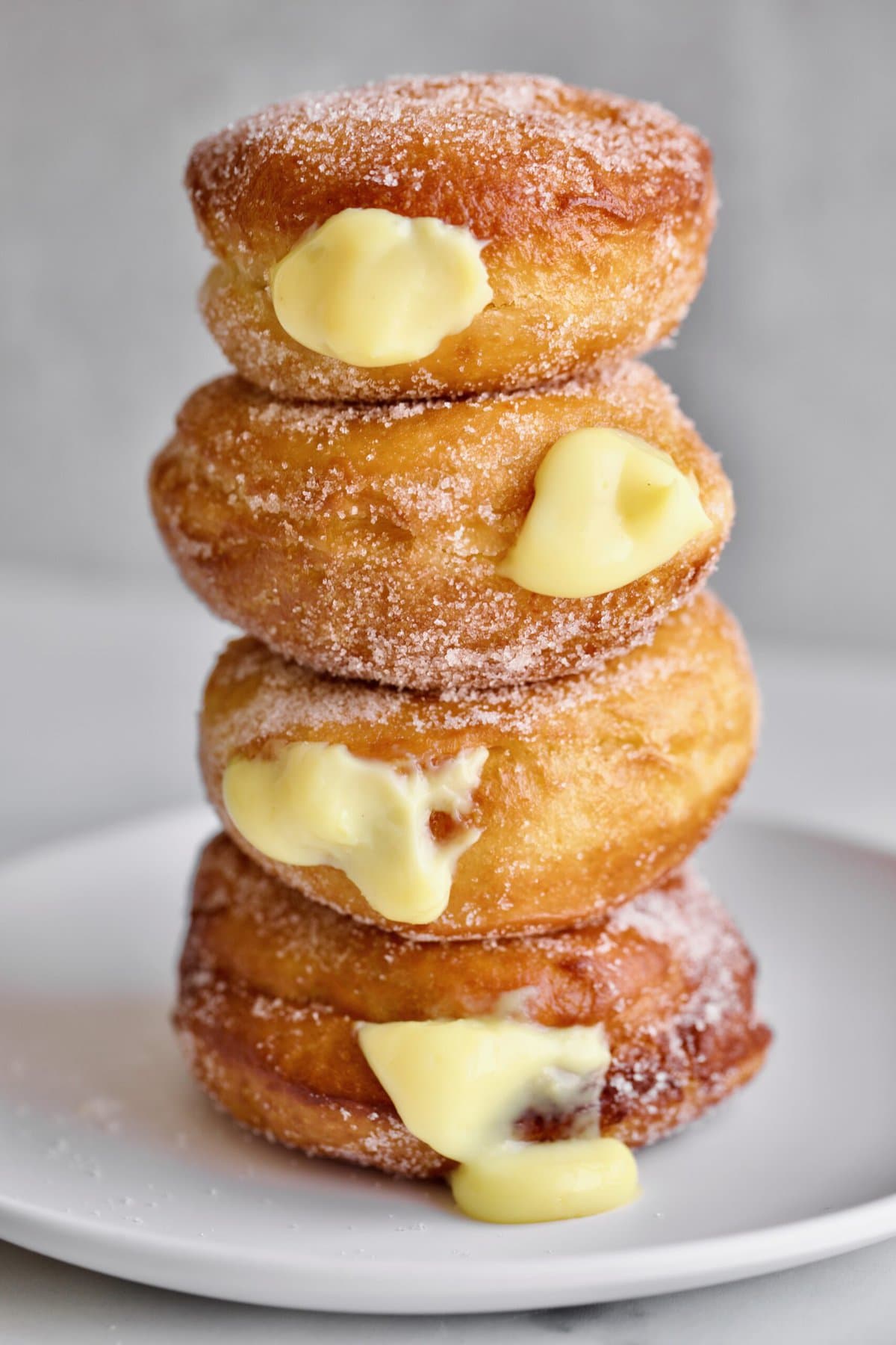 Bomboloni Recipe (Italian Donuts with Cream Filling) stacked on a plate 