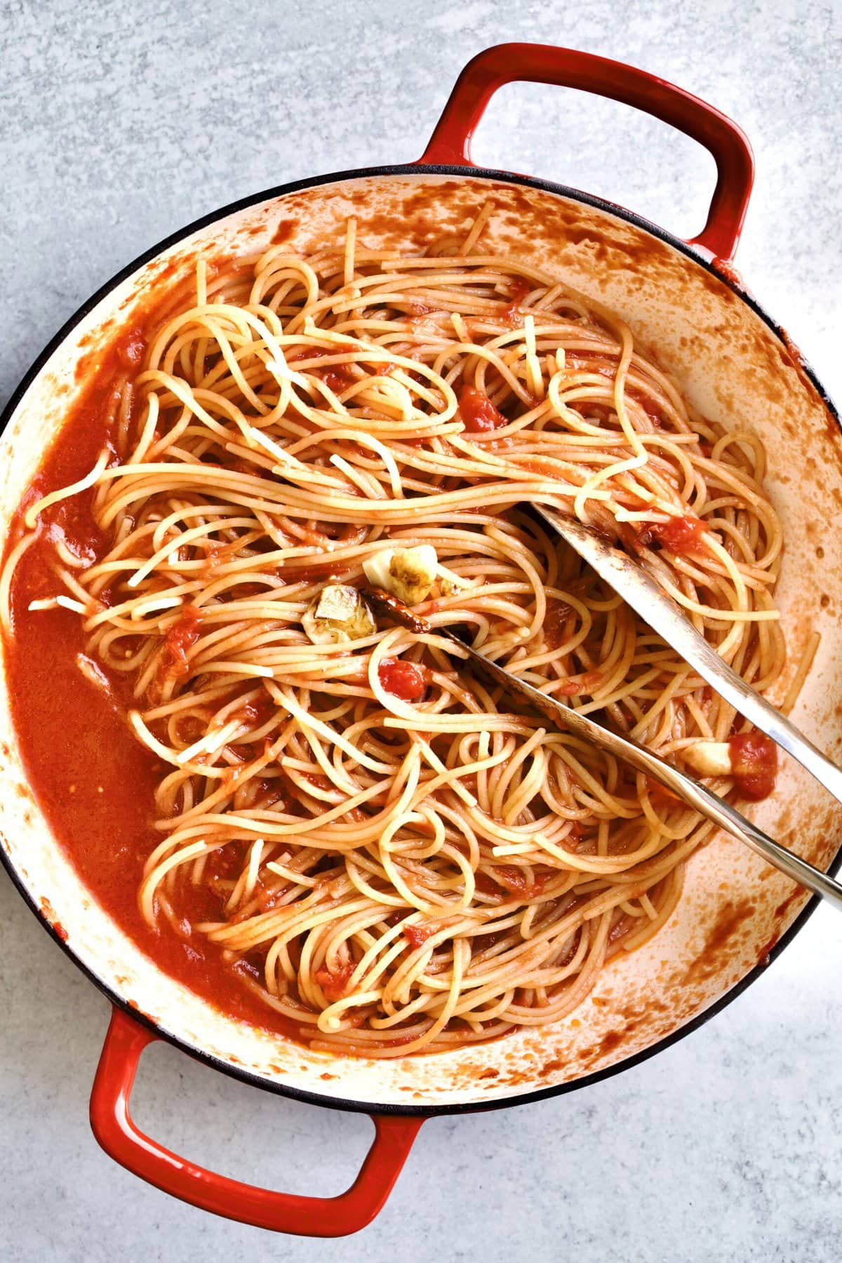 bow with spaghetti and tomato sauce with tongs