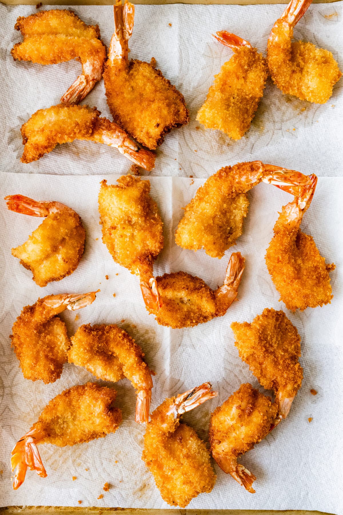 process for how to make Fried Butterfly Shrimp Recipe (Easy and Crunchy)- laying fried shrimp on paper towel to absorb excess oil
