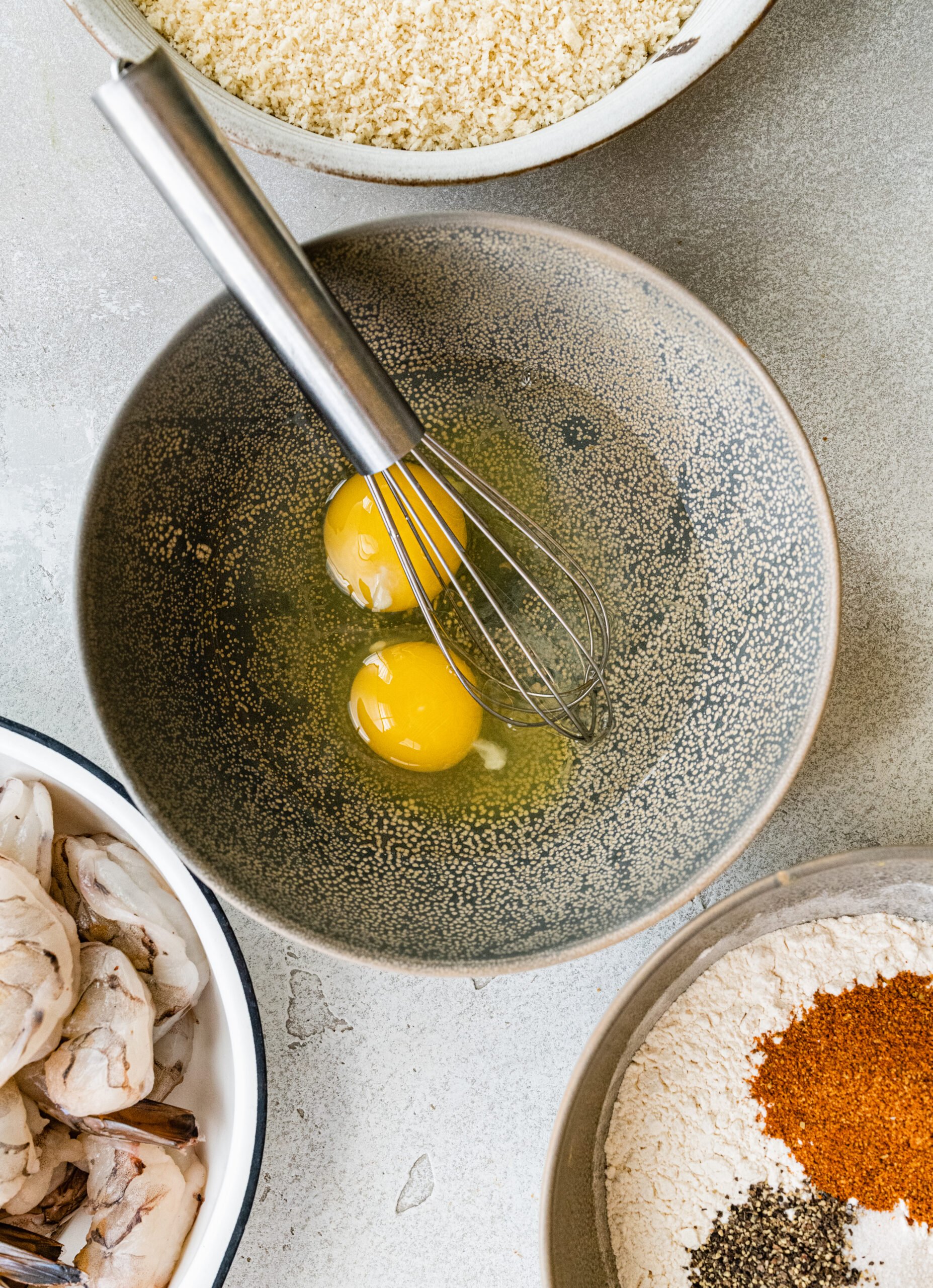 process for how to make Fried Butterfly Shrimp Recipe (Easy and Crunchy)- mixing the eggs with a whisk in a small bowl.