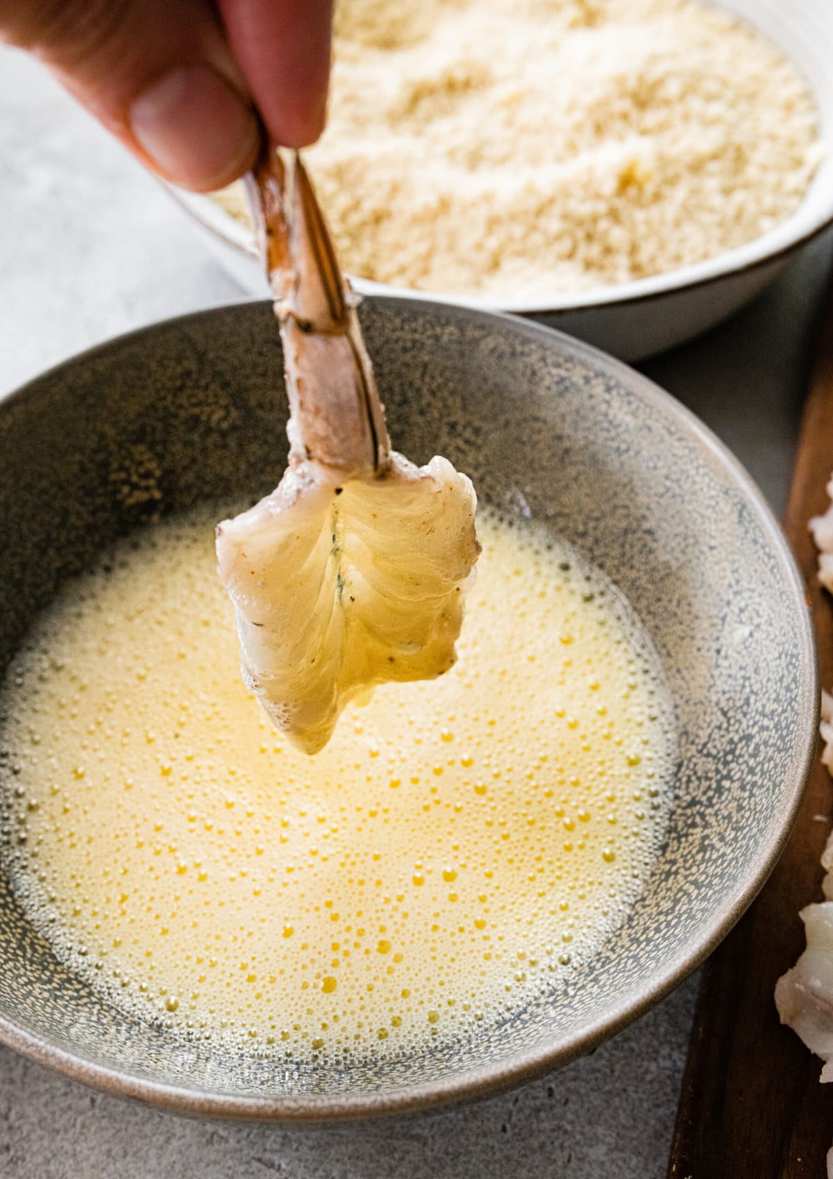 process for how to make Fried Butterfly Shrimp Recipe (Easy and Crunchy)- drenching the shrimp in the egg mixture.