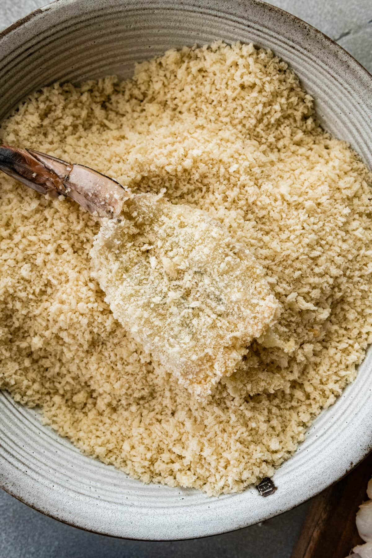 process for how to make Fried Butterfly Shrimp Recipe (Easy and Crunchy)- drenching the shrimp in the panko bread crumbs.