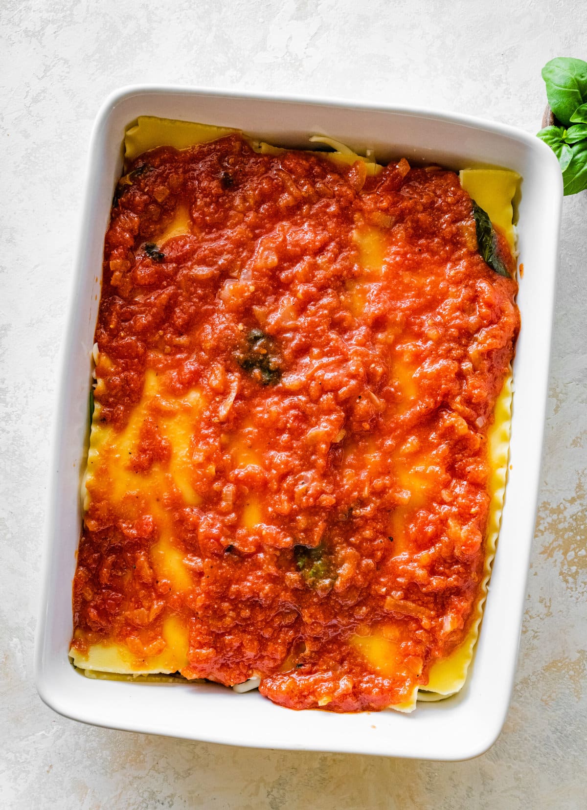 How to make Easy Mediterranean Lasagna Process- adding. more sauce on top of the layers of lasagna.