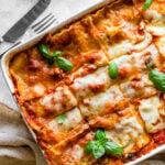 cut in slices of the mediterranean lasagna after it is baked in the oven with a cheesy top. Basil leaves as garnish.