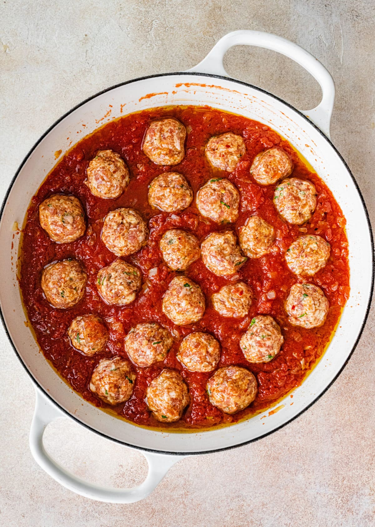 Process for making Italian Sausage Meatballs Recipe (In Sauce)- adding the raw meatballs to cook in sauce.