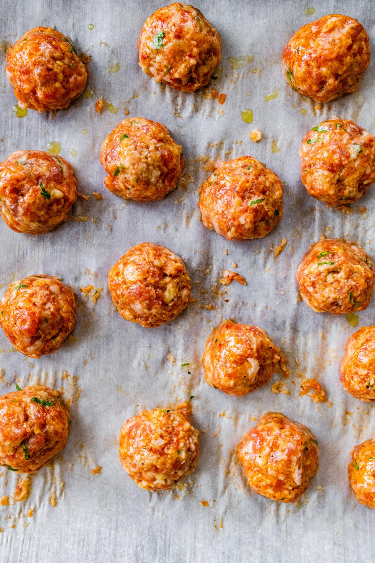 Process for making Italian Sausage Meatballs Recipe (In Sauce)- shaping the meatballs and placing on a baking sheet lined with parchment paper.