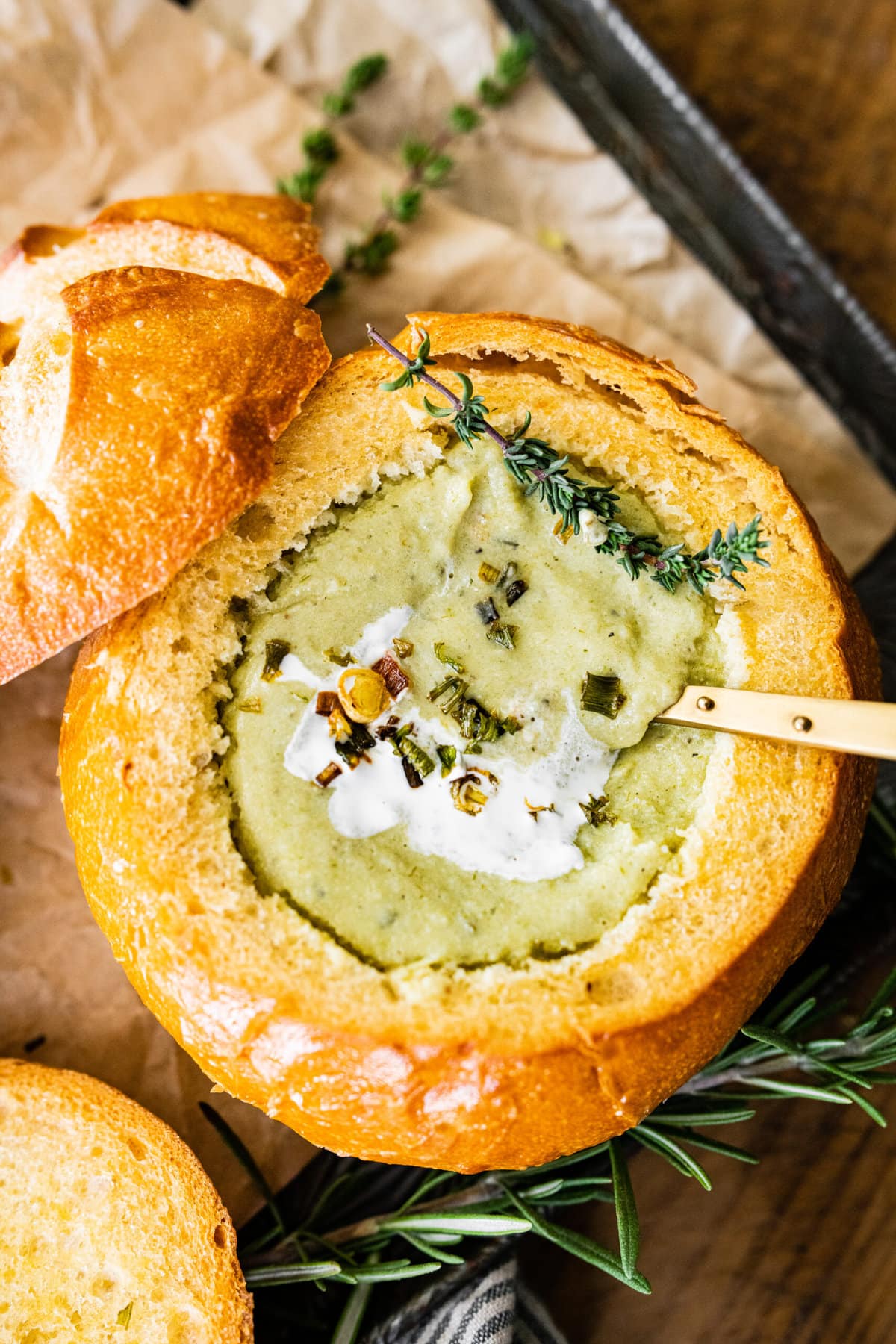 no potato leek soup recipe in a bread bowl with a spoon in it. A little bit of cream fraiche on the top.