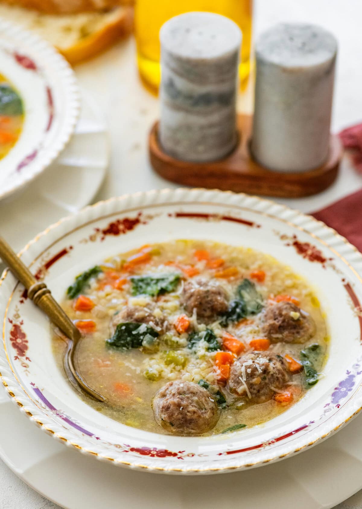 A bowl of authentic Italian wedding soup with a spoon in the bowl.