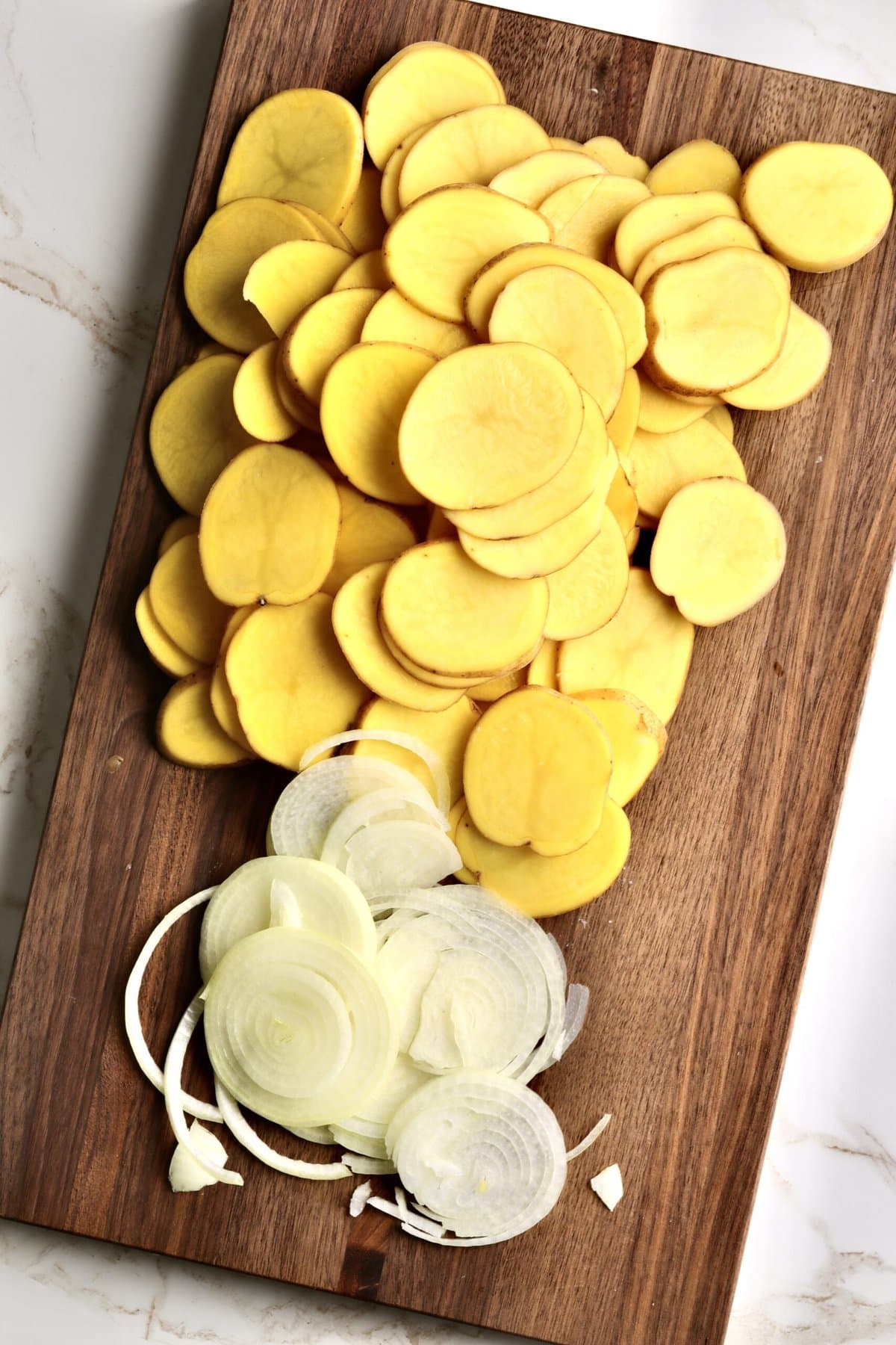 How to make Best Creamy Au Gratin Potatoes Recipe (Dad's Famous)- slicing the onions and potatoes in thin slices.