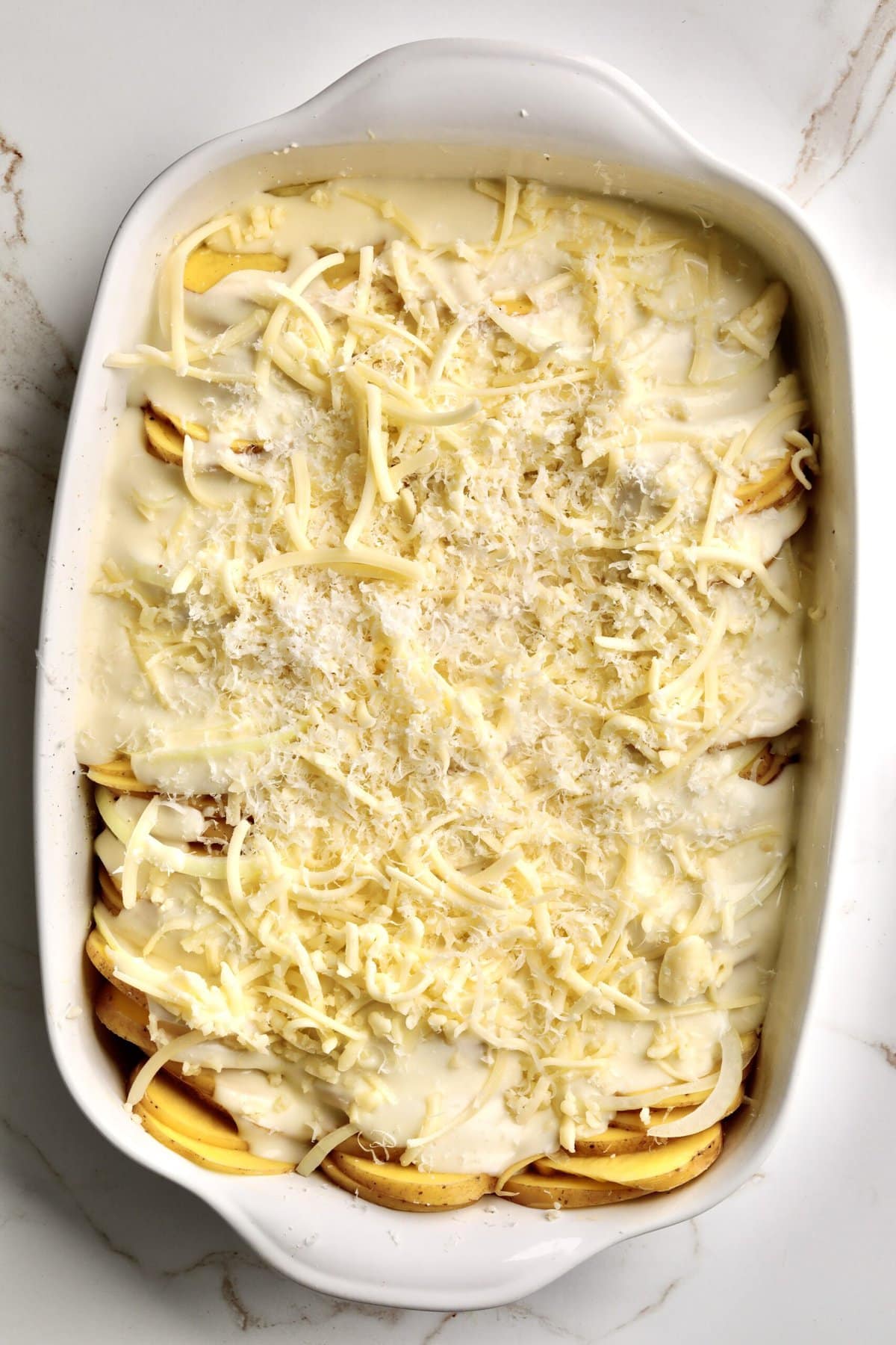 How to make Best Creamy Au Gratin Potatoes Recipe (Dad's Famous)- pour cheese sauce over the potatoes and cover with more cheese.