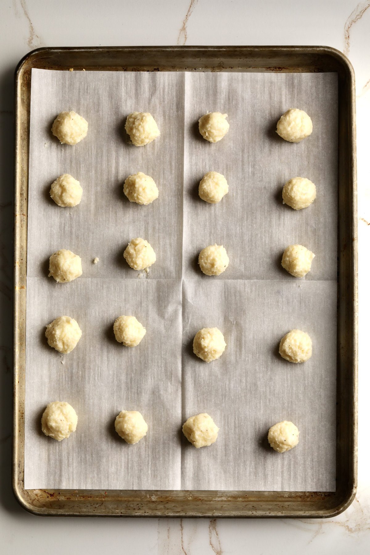 Process for making fried cheese balls- placing prepared cheese balls on parchment paper.
