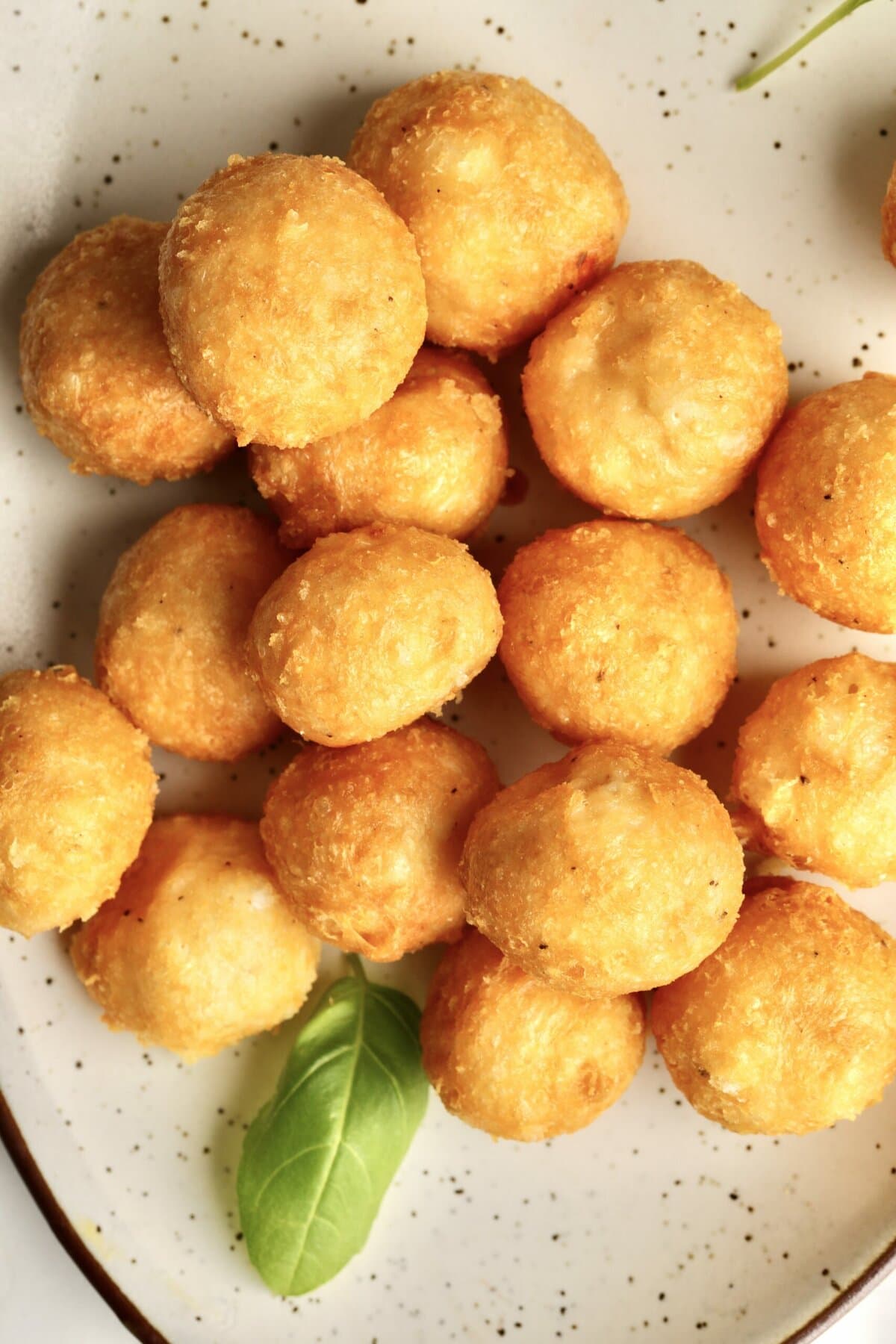 Easy Fried Cheese Balls Recipe (Crispy Bites) finished cheese balls on a plate.