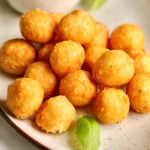 Pile of fried cheese balls on a plate.